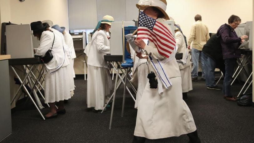 Women dressed as suffragettes cast ballots for the midterm elections at the Polk County Election Office on October 8, 2018 in Des Moines, Iowa, on the first day of early voting in the state.