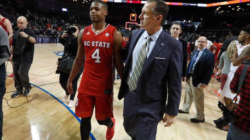 North Carolina State head coach Mark Gottfried walks off the floor with Dennis Smith Jr. (4) after a 75-61 loss against Clemson in the first round of the ACC Tournament at the Barclays Center in Brooklyn, N.Y., on March 7, 2017. (Ethan Hyman/Raleigh News &amp; Observer/TNS)