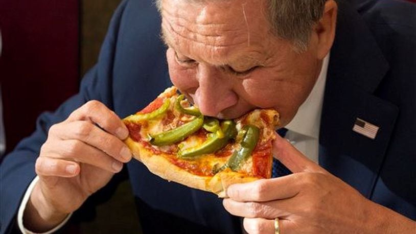Gov. John Kasich eats pizza WITHOUT a knife and fork, too. ASSOCIATED PRESS