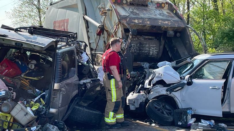A Rumpke garbage truck was stopped to pick up trash on West County Line Road when it was struck from behind by a Chevrolet Tahoe and a Mini Cooper Friday May 13, 2022. BILL LACKEY/STAFF