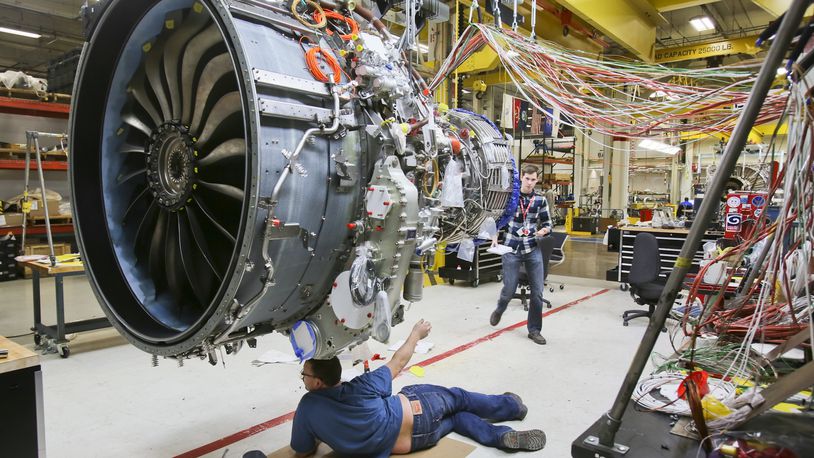 Engineers work on a LEAP commercial jet test engine at GE Aviation in Evendale in this December 2014 file photo. GREG LYNCH / STAFF