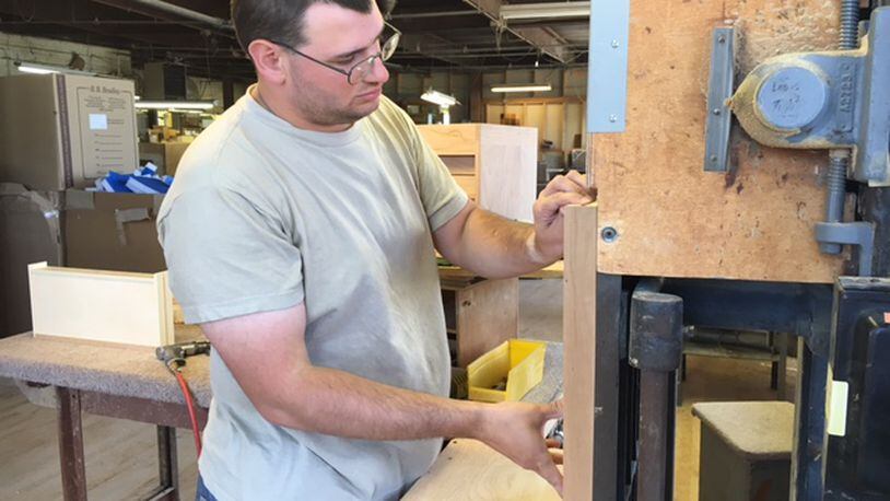 Worker Sean Maguire sands a wooden chest drawer for final fitting recently at Gerstner & Sons in Dayton. THOMAS GNAU/STAFF