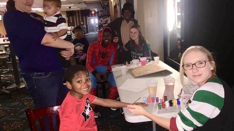 Volunteers do face painting for party guests at Jingle Bell Bowl. DEBBIE JUNIEWICZ / CONTRIBUTED