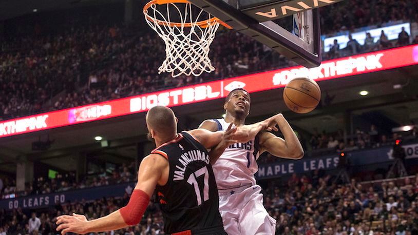 Dallas Mavericks guard Dennis Smith Jr., right, is fouled under the hoop by Toronto Raptors center Jonas Valanciunas, left, during second half NBA action in Toronto on Friday March 16, 2018. (Chris Young/The Canadian Press via AP)