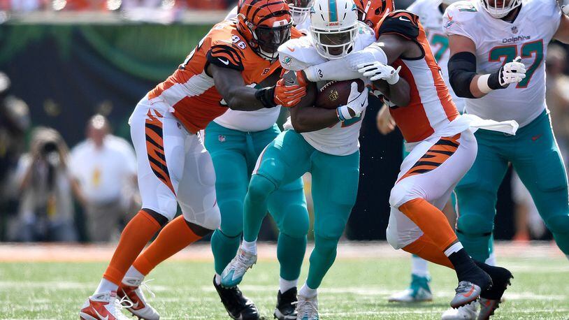 Preston Brown #52 of the Cincinnati Bengals and Carlos Dunlap #96 combine to tackle Kenyan Drake #32 of the Miami Dolphins during the first quarter at Paul Brown Stadium on October 7, 2018 in Cincinnati, Ohio. (Photo by Bobby Ellis/Getty Images)