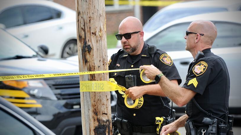 Montgomery County Sheriff's deputies stretch yellow crime scene tape around a utility pole after a boy was shot Wednesday, June 8, 2022, on Republic Drive in Harrison Twp. MARSHALL GORBY/STAFF