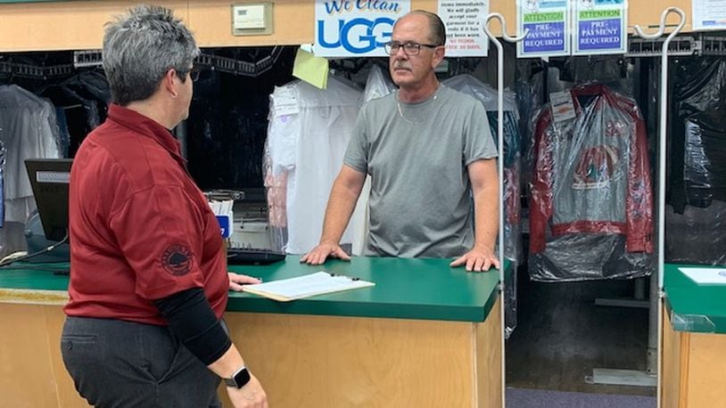 Cathi Spaugy, director of development for Harrison Twp., speaks with John Roberts, owner of Fox Cleaners on North Main Street, about the BusinessFirst! initiative and the help available to him. EMILY KRONENBERGER/STAFF PHOTO