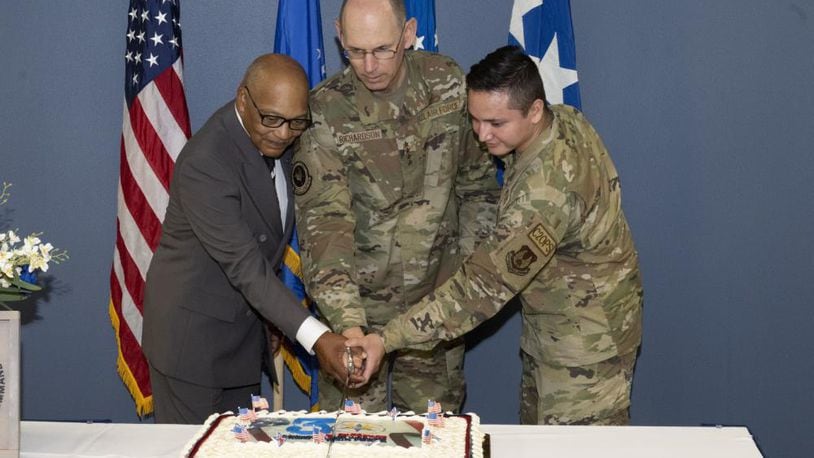 Gen. Duke Richardson, commander of Air Force Materiel Command, cuts the cake to commemorate the 30th anniversary of AFMC. The ceremony marking the history and heritage took place at Wright-Patterson Air Force Base July 11. Assisting the general (from left) is Wright-Patterson AFB’s longest serving civilian, Fred Bennett, and WPAFB’s most junior Airman, Airman 1st Class Robert Hernandez. (U.S. Air Force photo by Jerry Bynum)