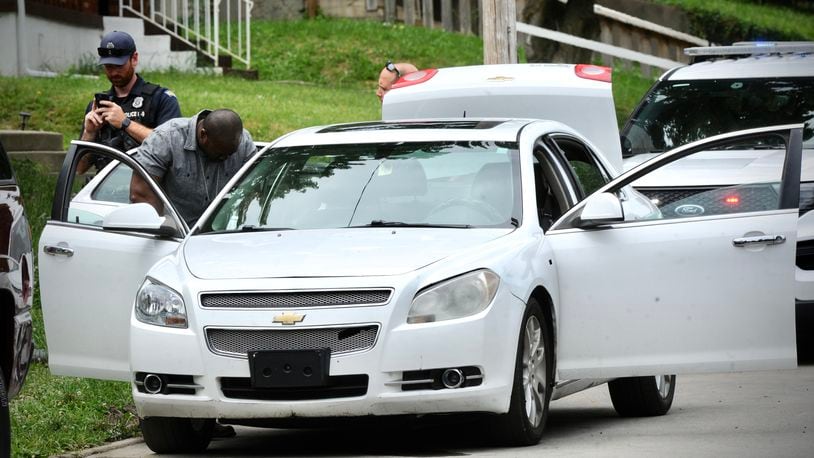 Dayton police search the car of a man who fired shots into the air Wednesday, June 8, 2022, in the 100 block of Marathon Avenue. MARSHALL GORBY/STAFF