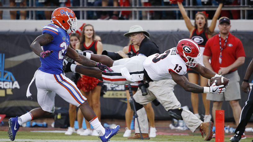2017 File photo:  Elijah Holyfield #13 of the Georgia Bulldogs dives into the end zone for a 39-yard touchdown in the fourth quarter of a game against the Florida Gators at EverBank Field on October 28, 2017 in Jacksonville, Florida. Georgia defeated Florida 42-7. (Photo by Joe Robbins/Getty Images)