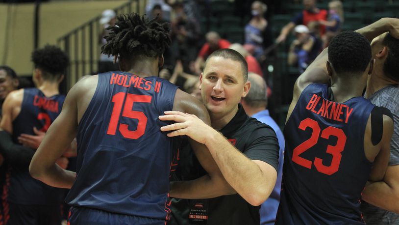 Dayton's Neil Sullivan hugs DaRon Holmes II after a victory against Kansas in the semifinals of the ESPN Events Invitational on Friday, Nov. 26, 2021, at HP Fieldhouse in Kissimmee, Fla. David Jablonski/Staff