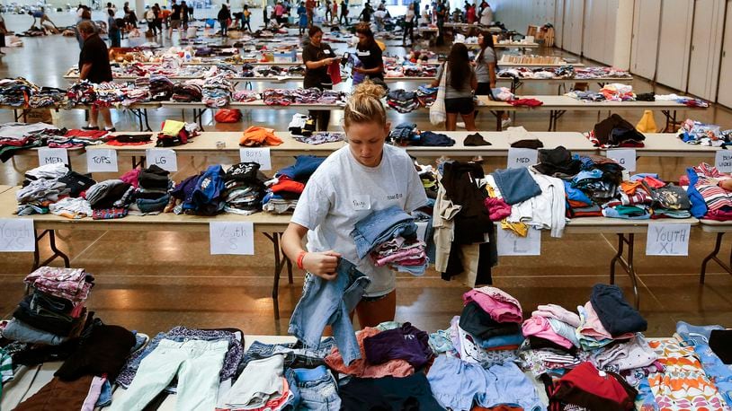 Volunteer Paige Atkinson sorts donated clothing at NRG Center, which opened its doors to evacuees in the wake of Tropical Storm Harvey Wednesday, Aug. 30, 2017 in Houston. Officials say nearly all Houston-area waterways inundated by Harvey’s record rainfall have crested, but that water levels continue to rise in two flood-control reservoirs. (Michael Ciaglo /Houston Chronicle via AP)