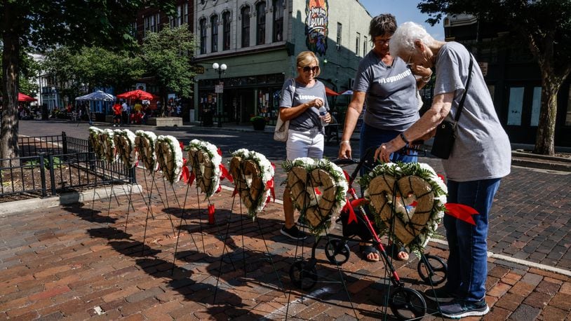 The family of Oregon District shooting victim Logan Turner, from left Kathy Turner, Susan Scherbauer and Chris Wuebben, visit the memorial for the nine victims Friday, Aug. 4, 2023, during a remembrance on the fourth anniversary. JIM NOELKER/STAFF