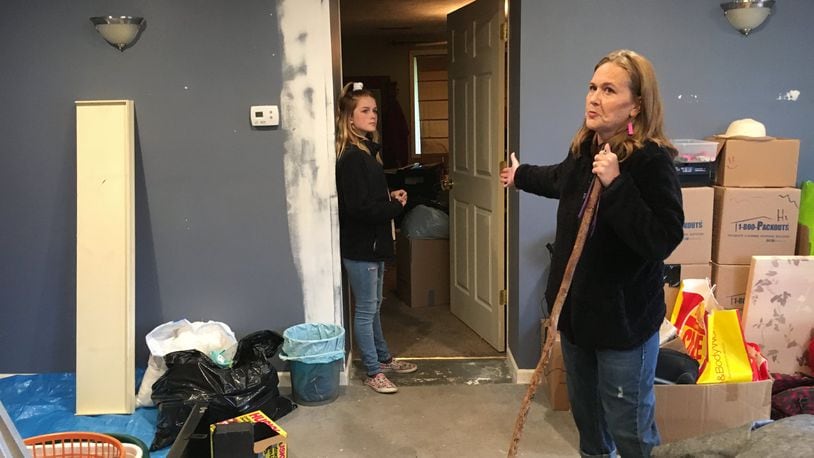 Julia Stewart of Beavercreek and her 11-year-old daughter Averi show the finished garage space their family is moving into while they fight with insurance over repairs to the rest of the house.