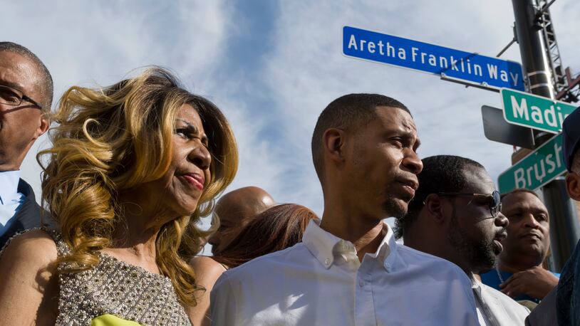 Aretha Franklin and her son Kecalf Cunningham stand under the newly unveiled street sign in front of the Music Hall in Detroit, June 8, 2017. (David Guralnick/Detroit News via AP)