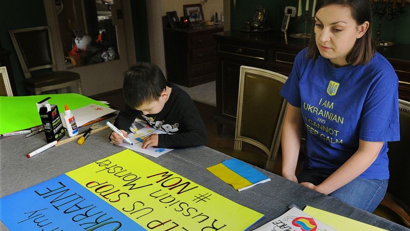Anastasia Nagle with her son Christoper, age 6, prepare posters for an upcoming rally to show support for the Ukraine. MARSHALL GORBY\STAFF