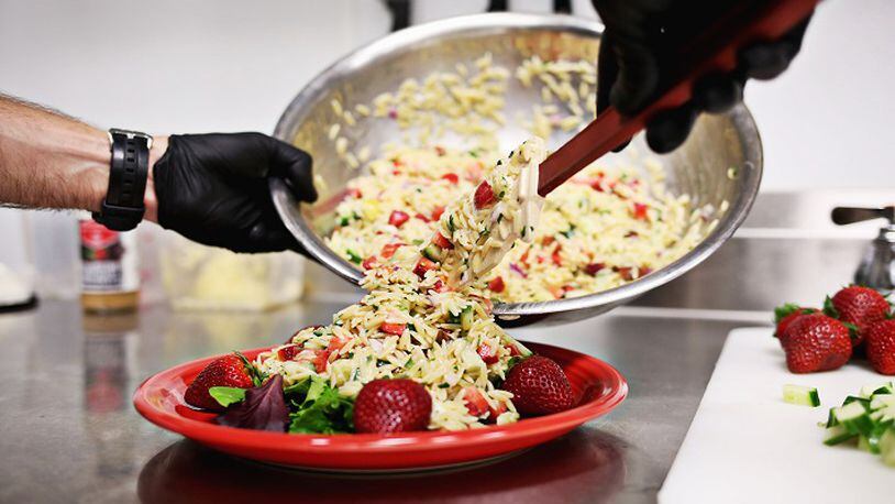 Adam Dillard of Berry Brothers makes his orzo pasta salad with the company's Strawberry Rosemary Vinaigrette May 11, 2018, in Raleigh.  (Juli Leonard/Raleigh News & Observer/TNS)