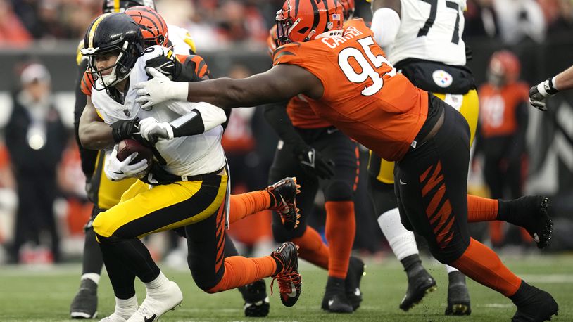 Pittsburgh Steelers quarterback Kenny Pickett (8) is sacked by Cincinnati Bengals defensive tackle Zach Carter, right, and Myles Murphy, rear, during the second half of an NFL football game in Cincinnati, Sunday, Nov. 26, 2023. (AP Photo/Carolyn Kaster)