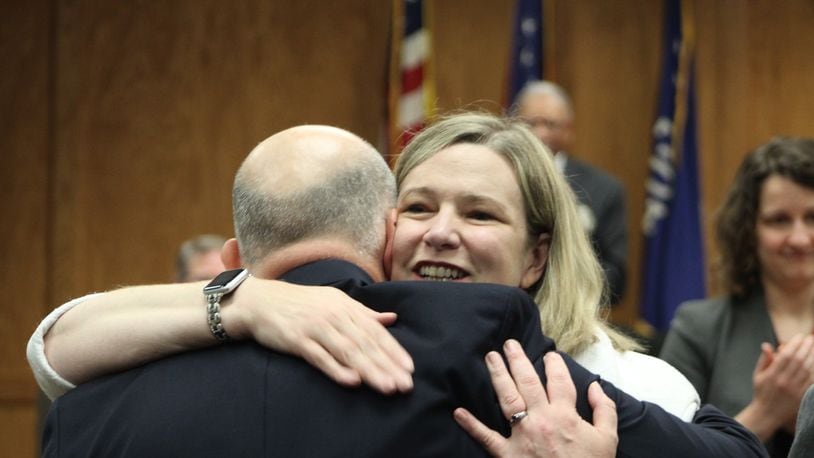 Dayton Mayor Nan Whaley on Wednesday hugs Health Commissioner Jeff Cooper during the city commission's first in-person meeting in 15 months. Whaley presented Keys to the City to Cooper and two other officials with Public Health -- Dayton & Montgomery County. CORNELIUS FROLIK / STAFF