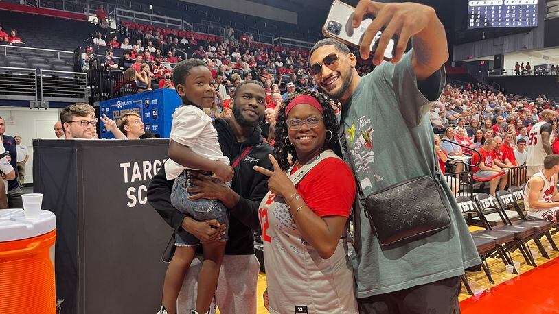 Trey Landers' mom, Tracy Matthews, poses for a photo with Obi Toppin, right, and Jalen Crutcher, left, at The Basketball Tournament on Sunday, July 24, 2022, at UD Arena. David Jablonski/Staff