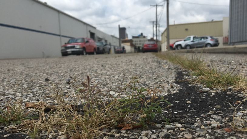 Pond Street, near the 2nd Street Market in the Webster Station neighborhood, has one of the lowest Pavement Condition Index Scores in Dayton. The street, which runs for a block next to a heat treating company, has grass growing out of spots and is coverd in cracks. CORNELIUS FROLIK / STAFF