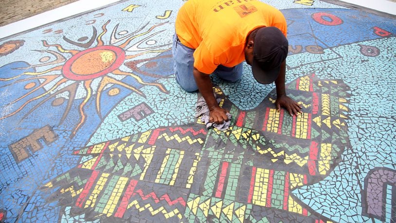 "Together We Rise," is a new large-scale play area and work of art in West Dayton. The in-ground mosaic is a play station designed with interactive games, alphabet letters and raised areas for crayon rubbings. It is located in a playground at the intersection of Harvard Boulevard and Burroughs Drive on the Omega CDC Harvard Campus.  LISA POWELL / STAFF