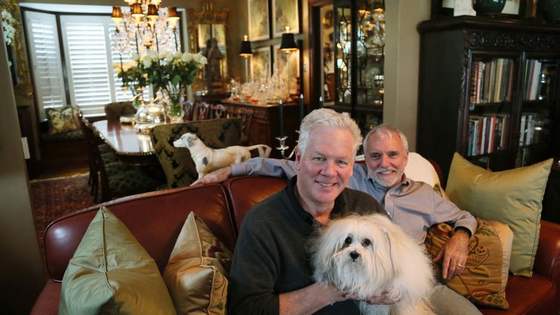 Craig Burfield (left), John Nellesen and Victoria, a four-year-old Coton de Tulear, in their home in the Carondelet neighborhood on Thursday, Aug. 19, 2018, in St. Louis. (Chris Lee/St. Louis Post-Dispatch/TNS)