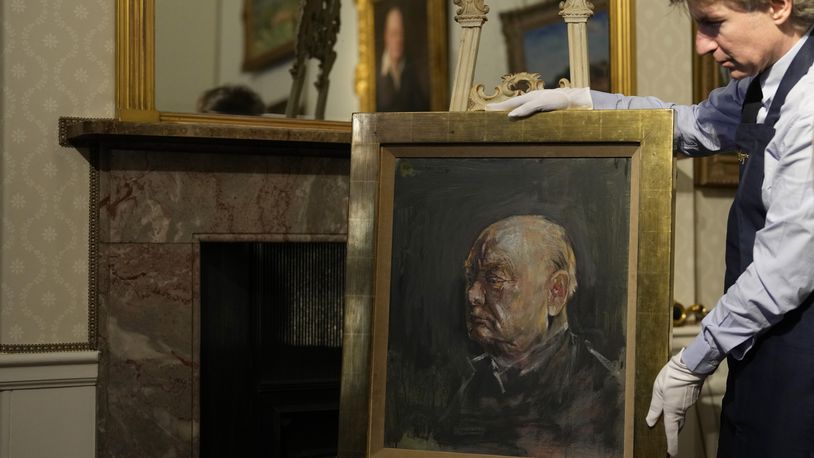 A member of staff from Sotheby's poses for the media with a portrait of the iconic former British Prime Minister Winston Churchill, painted by Graham Sutherland in 1954, at Blenheim Palace, Woodstock, England, Tuesday, April 16, 2024. The portrait will be sold at auction on June 6 with an estimated price of 500-800,000 pounds sterling (US621, 000-1,000,000). Churchill was born at Blenheim Palace on Nov. 30, 1874. (AP Photo/Alastair Grant)