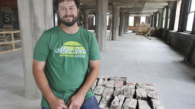 Jeff Graley, founder and CEO, of the Dayton software firm Mile Two, poses for a photo in his companies new location at the Manhattan on Third Street. MARSHALL GORBY\STAFF