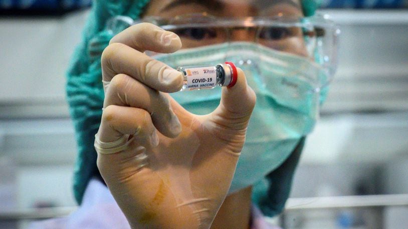 This May photo shows a laboratory technician holding a dose of a COVID-19 novel coronavirus vaccine candidate ready for trial on monkeys at the National Primate Research Center of Thailand at Chulalongkorn University in Saraburi. (Mladen Antonov/AFP/Getty Images/TNS)