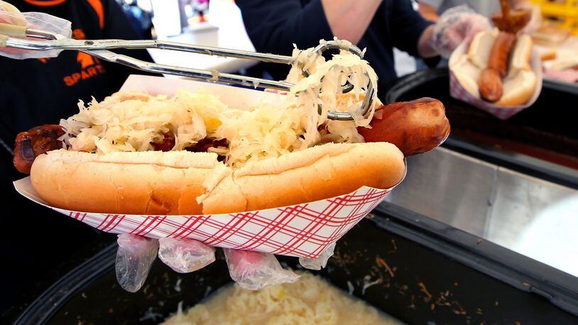 A giant hot dog is topped with sauerkraut at the Hawg Dawgs booth, supporting the Waynesville High School’s athletic boosters, during Saturday’s Sauerkraut Festival in Waynesville, Ohio, Oct. 12, 2013. NICK DAGGY / STAFF
