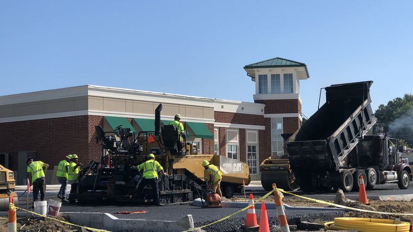 Workers added asphalt to the parking lot in front of the Performing Arts Center scheduled to open next week in Springboro. STAFF/LAWRENCE BUDD