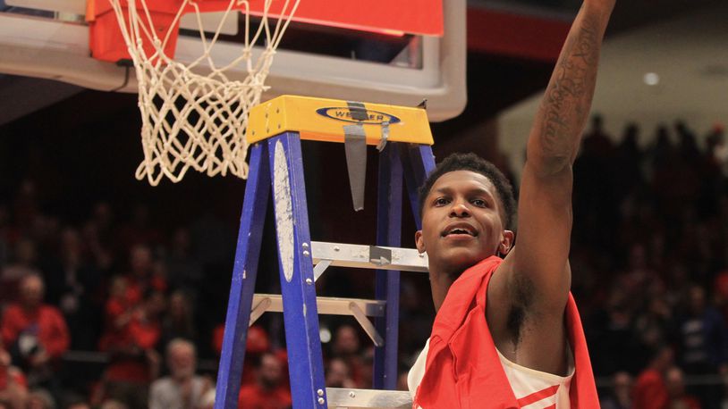 Dayton’s Dwayne Cohill cuts off a piece of the net after a victory against George Washington on March 7, 2020, at UD Arena. David Jablonski/Staff