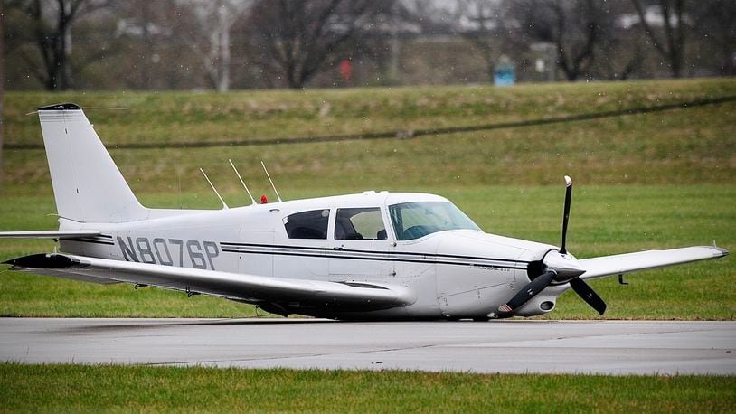 A Piper Comanche landed on its belly Wednesday afternoon, Nov. 16, 2022, on the runway at the Moraine Airpark after its retractable gear did not lower. MARSHALL GORBY/STAFF