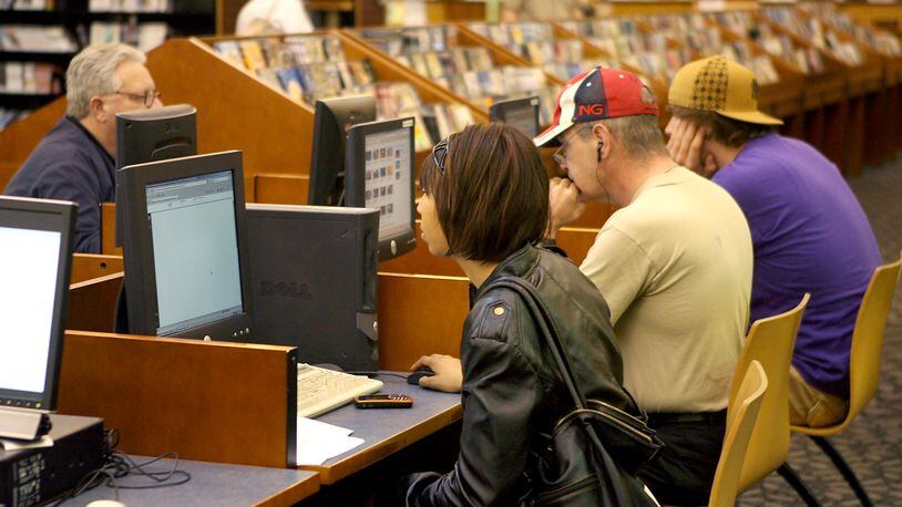 Patrons use the computer stations at the Fairfield Lane Library. GREG LYNCH/STAFF