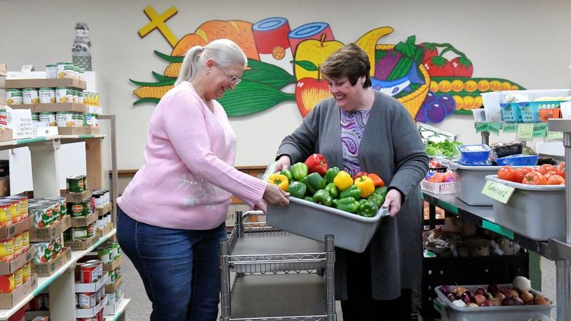 Donna Wilkerson (left) and Sharon Buse prepare offerings for clients at the First Place Food Pantry in Troy. Contributed photo.