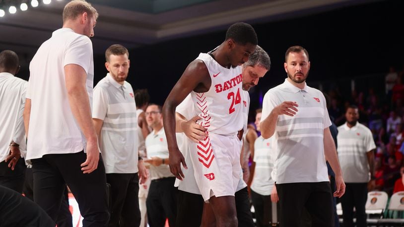 Dayton's Kobe Elvis is helped to the locker room by trainer Mike Mulcahey after an injury in the second half during a game against BYU in the Battle 4 Atlantis on Friday, Nov. 25, in Nassau, Bahamas. David Jablonski/Staff