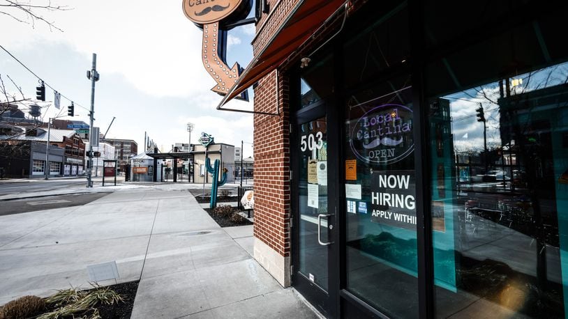 The Local Cantina on Est First St. in Dayton has a help wanted sign on the front door. JIM NOELER/STAFF