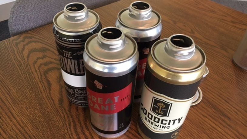 An assortment of “crowlers” — “cans” plus “growlers” — ready for someone’s favorite lager. Dayton Systems Group in Miami Twp. developed the resealable tops to the cans. THOMAS GNAU/STAFF