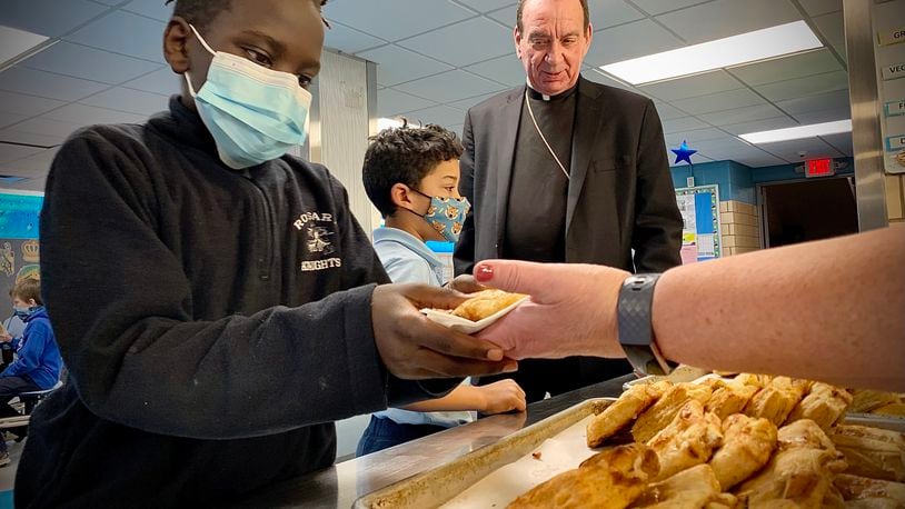 Archbishop of Cincinnati Dennis M. Schnurr, shares baked treats Tuesday, March 1, 2022 before lent with students at the Our Lady of the Rosary Elementary School. MARSHALL GORBY\STAFF