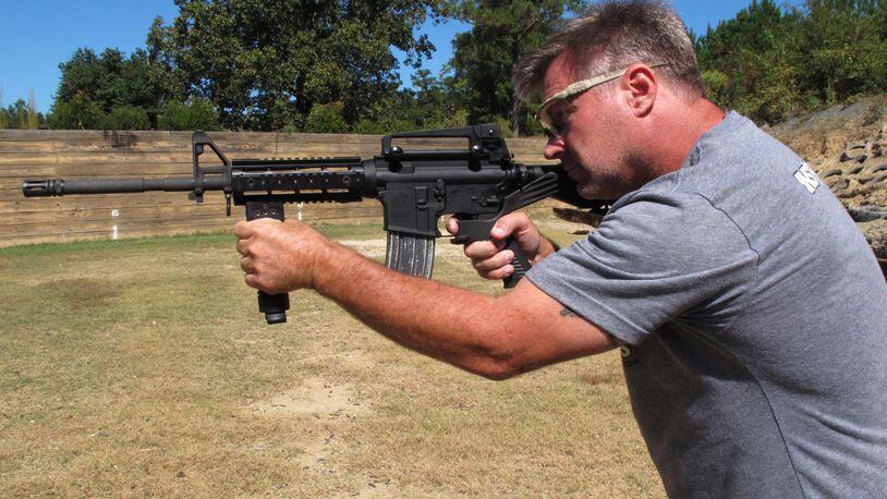Shooting instructor Frankie McRae aims an AR-15 rifle fitted with a “bump stock” at his 37 PSR Gun Club in Bunnlevel, N.C., on Wednesday, Oct. 4, 2017. The stock uses the recoil of the semiautomatic rifle to let the finger “bump” the trigger, making it different from a fully automatic machine gun, which are illegal for most civilians to own. (AP Photo/Allen G. Breed)