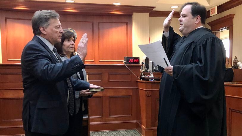 Joseph Statzer is sworn in as acting Butler County auditor Thursday, Dec. 29, 2022. He is seen here alongside his wife, Amy. At right is Judge John M. Holcomb of the Butler County Common Pleas Court, Probate Division. CONTRIBUTED
