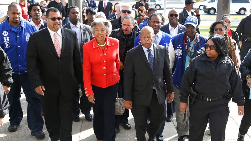 Civil right icon, U.S. Rep. John Lewis (center) leads a group to the Montgomery County Board of Elections Friday for early voting after speaking at a rally at Sinclair Community College. At left is U.S. Rep. Joyce Beatty, D-Columbus. attended a get out the vote rally at Sinclair Community College in Dayton Friday.  LISA POWELL / STAFF