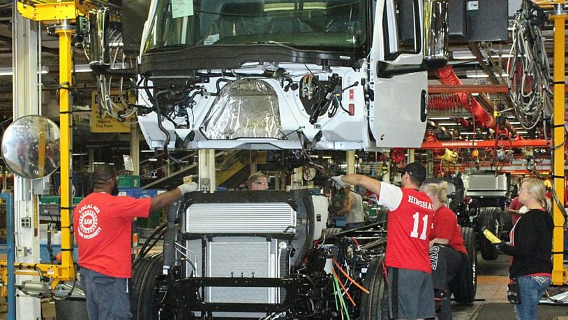 Navistar International employees put together a truck on the assembly line in a 2018 photo. JEFF GUERINI/STAFF