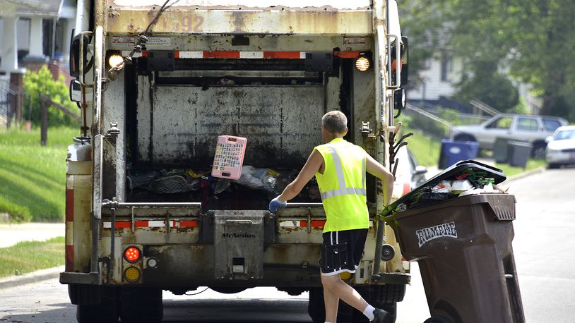 A Rumpke garbage truck picks up trash from a residence in. Bill Lackey/Staff