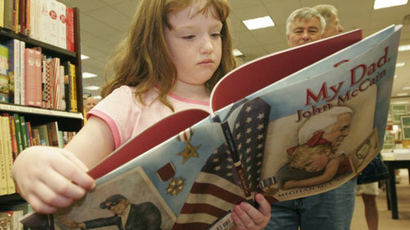 A young girl reads a book from the shelves of Barnes & Noble.