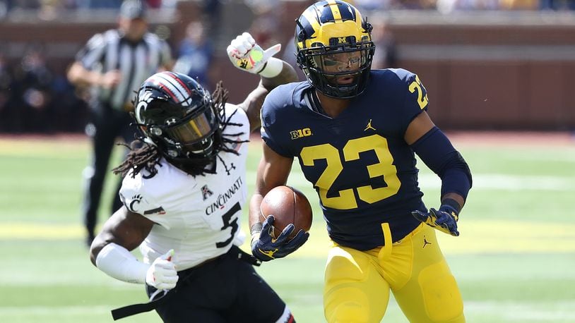 ANN ARBOR, MI - SEPTEMBER 9: Tyree Kinnel #23 of the Michigan Wolverines intercepts the ball and scores a first quarter touchdown as Mike Boone #5 of the Cincinnati Bearcats gives chase at Michigan Stadium on September 9, 2017 in Ann Arbor, Michigan.(Photo by Leon Halip/Getty Images)