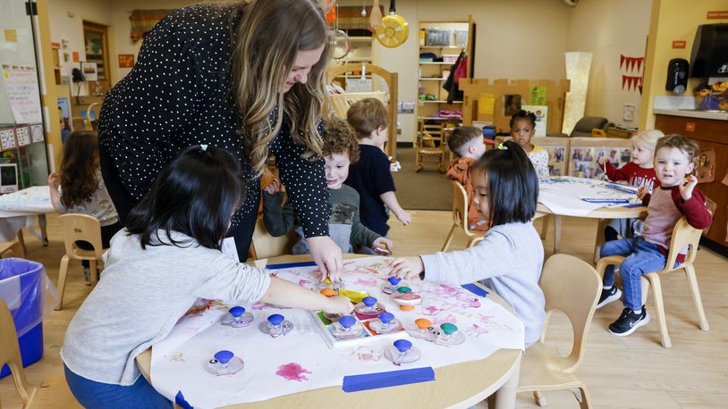 Childcare Director Lauren Kolks helps students with a craft project in the pre-k class at Mini University, a child development center on the Miami  University campus,  Thursday, April 6, 2023 in Oxford. NICK GRAHAM/STAFF