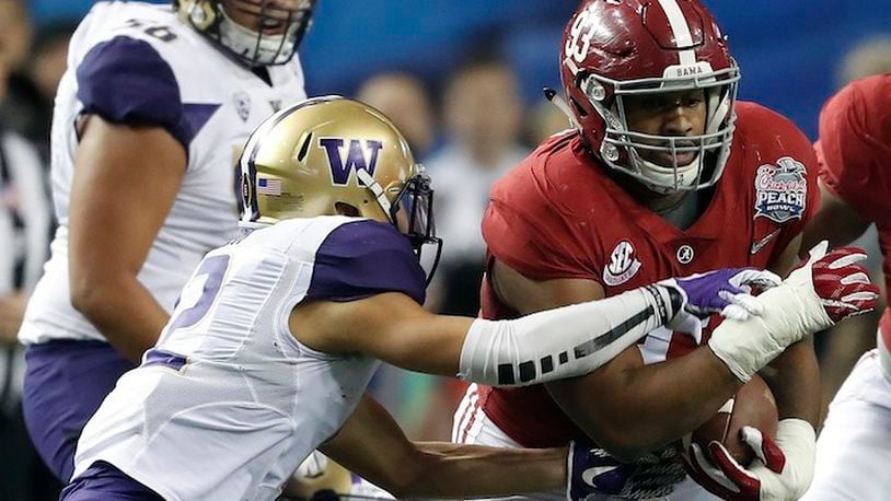 Alabama defensive lineman Jonathan Allen (93) runs after recovering a fumble as Washington wide receiver Aaron Fuller (12) defends during the first half of the Peach Bowl NCAA college football playoff game, Saturday, Dec. 31, 2016, in Atlanta. (AP Photo/John Bazemore)