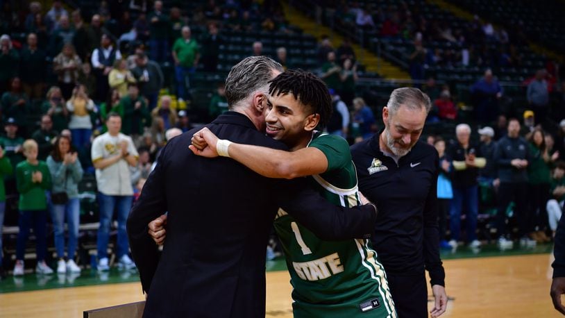 Wright State's Trey Calvin is embraced by athletic director Bob Grant as coach Scott Nagy looks on during SenIor Night ceremones Saturday at the Nutter Center. Joe Craven/WSU Athletics